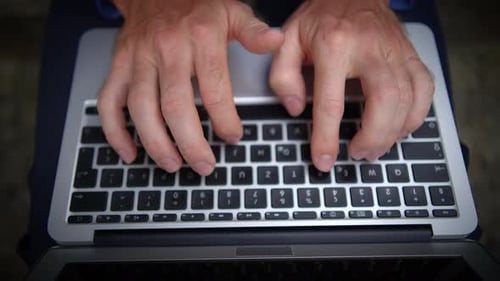 Man Typing on Laptop Sitting on Concrete Steps