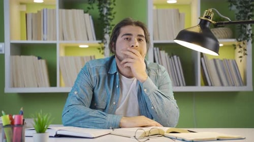 Gelangweiliger und widerwilliger männlicher Student beim Lernen.