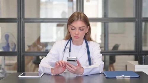 Female Doctor Using Smartphone in Clinic