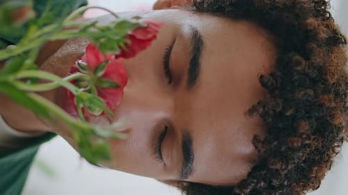 Young Adult Smiling Peacefully with Red Flowers