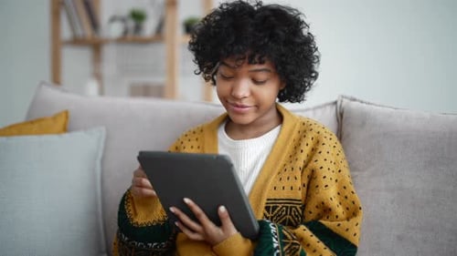 Woman Uses Tablet at Home on Couch