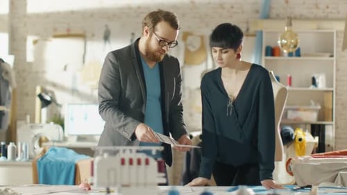 Female and Male fashion, designer, Choosing Sketches for Their New Clothing Collection. Studio is