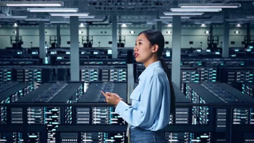 Side View Of Asian Business Woman Using Mobile Phone An Looking Around In Data Center