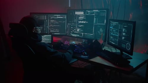 Young Adult Coding at Night on Multiple Computers