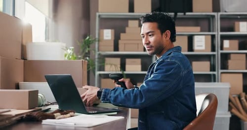 Man Scanning Package and Typing on Laptop Indoors