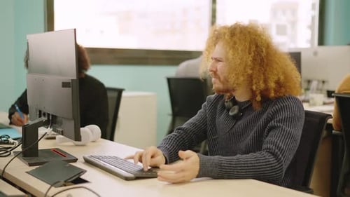 Young Adult Working at Computer with Frustration
