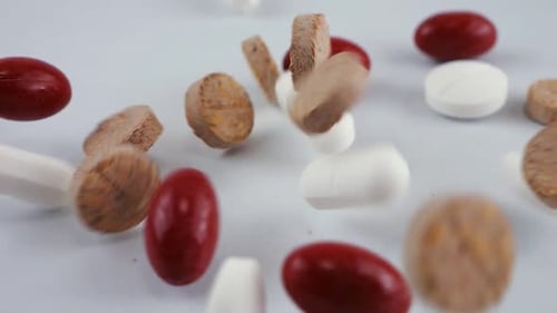 Falling tablets and pills. Slow motion. Medicine and healthy. Close up of capsules.