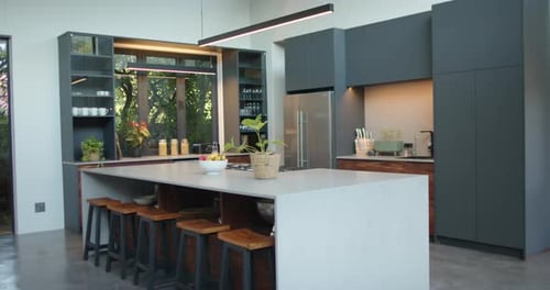 Modern kitchen with island, bar stools, and sleek cabinets in contemporary home, copy space