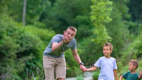 Young dad points up in air to show his boys something, bokeh, Slovenia