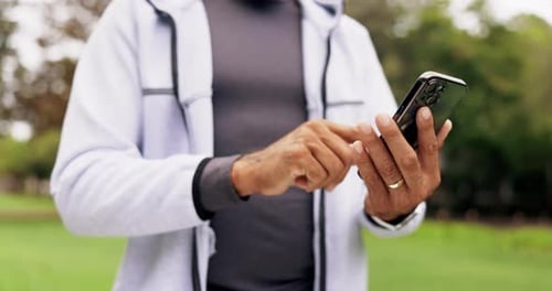 Adult Hands Using Smartphone Device in Park