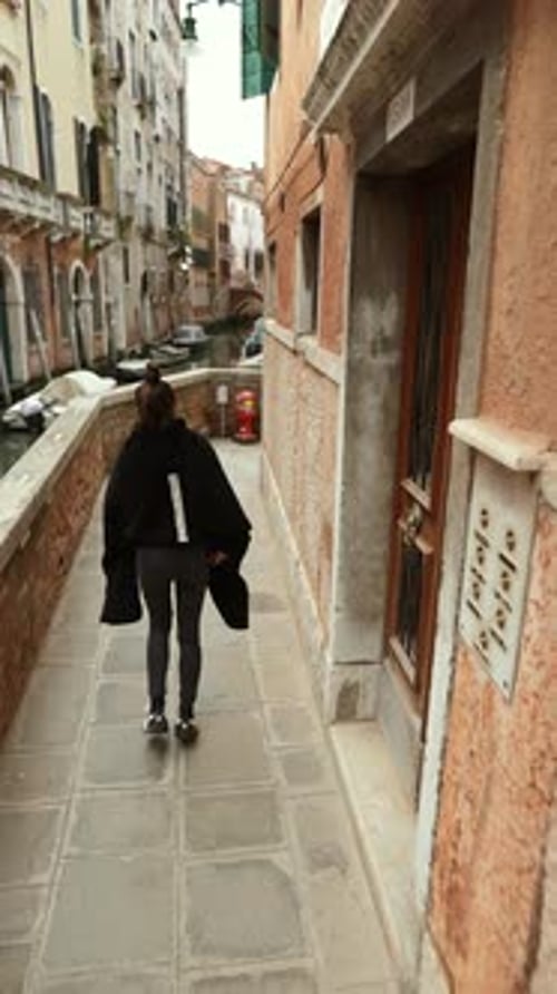 Venice Italy A Tourist Girl Explores the Streets of the City Capturing Moments on Her Smartphone