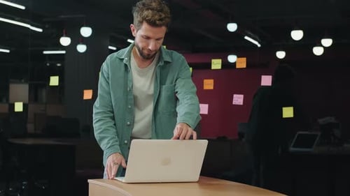 European Businessman Works in the Office Using a Laptop