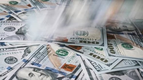 100-Dollar-Scheine fallen auf einen rotierenden Dollarstapel. Nahaufnahme