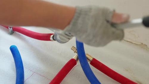 Close-Up of Plumber Using a Crimping Tool on PEX Pipes
