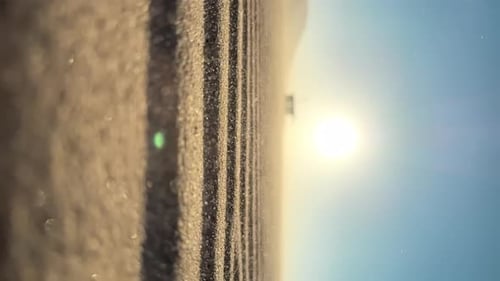 Closeup of Sand Falling Down on the Road at the Beach