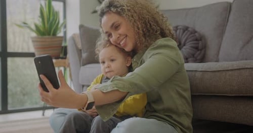 Smiling Woman Takes Selfie with Child in Living Room