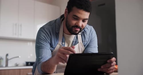 Man Uses Tablet Device in Bright Modern Kitchen