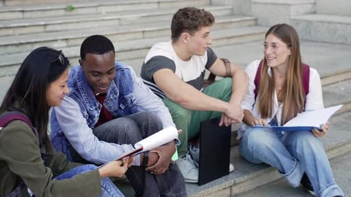 University Student Studying for the Exams Sitting on Staircase