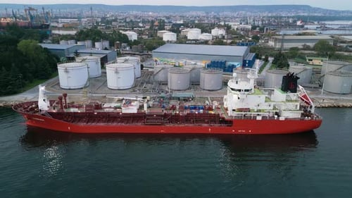 Tanker Ship Refueling at an Oil Terminal with Storage Silo's in the Port Aerial View