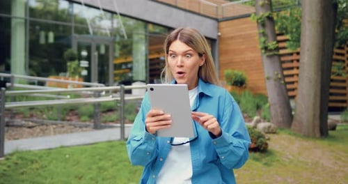 Close Up of Amazed Woman Holds Digital Tablet Reading Good News Happy to Receive Notification