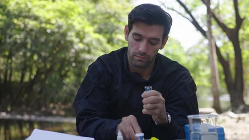 The environmentalist is testing a water Stream in the forest.