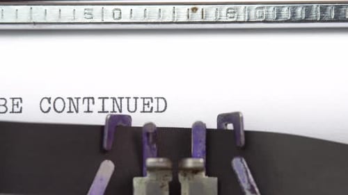 To Be Continued phrase closeup being typing and centered on a sheet of paper on old vintage