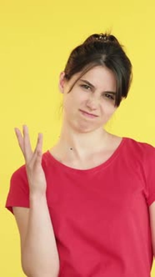 Woman Using Hand Gestures on Bright Yellow Background