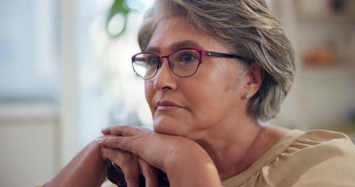Thoughtful Elderly Woman Resting on Cane Indoors