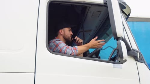 Semi Truck Driver Making Conversation with Other Truck Drivers Through CB Radio Right Hand Drive Car