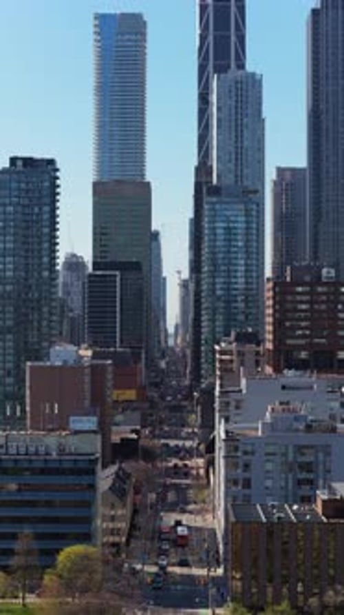 Vertical Video of Towering Glass Skyscrapers and City Street Canyon in Downtown Toronto Ontario with