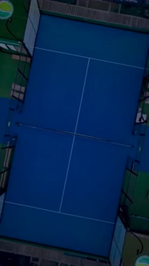 Vertical Video Dynamic Paddle Tennis Match Seen From Above on a Vibrant Outdoor Court