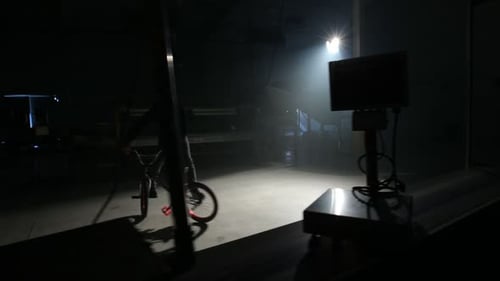 Young bmx rider performs thrilling stunts in an abandoned warehouse