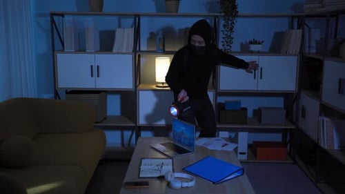 Masked Thief Searches Home at Night with Flashlight