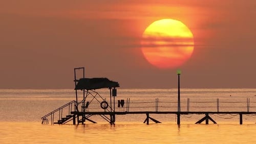 Sunrise Over Pier in Sea