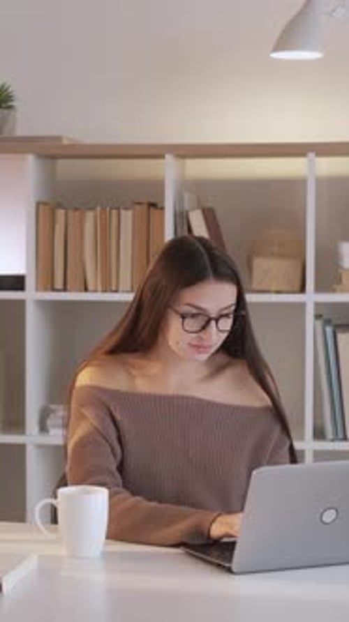 Young Woman Working on Laptop at Desk