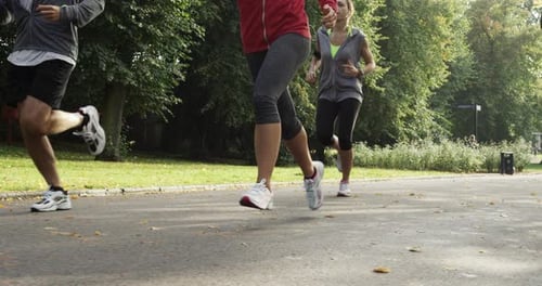 4k video footage of a group of young friends jogging together through the park