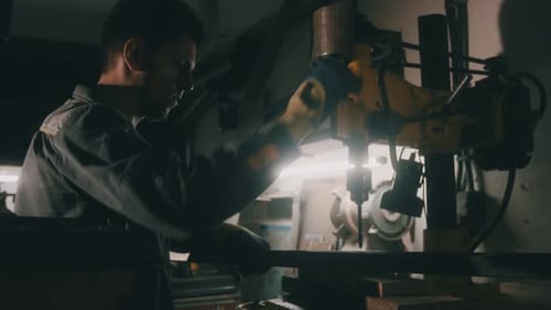 Ein Arbeiter arbeitet in einer Werkstatt an einer Metallbohrmaschine