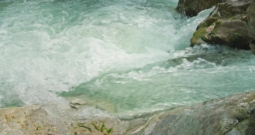 Cold mountain river with clear glacial water flows in a rocky gorge
