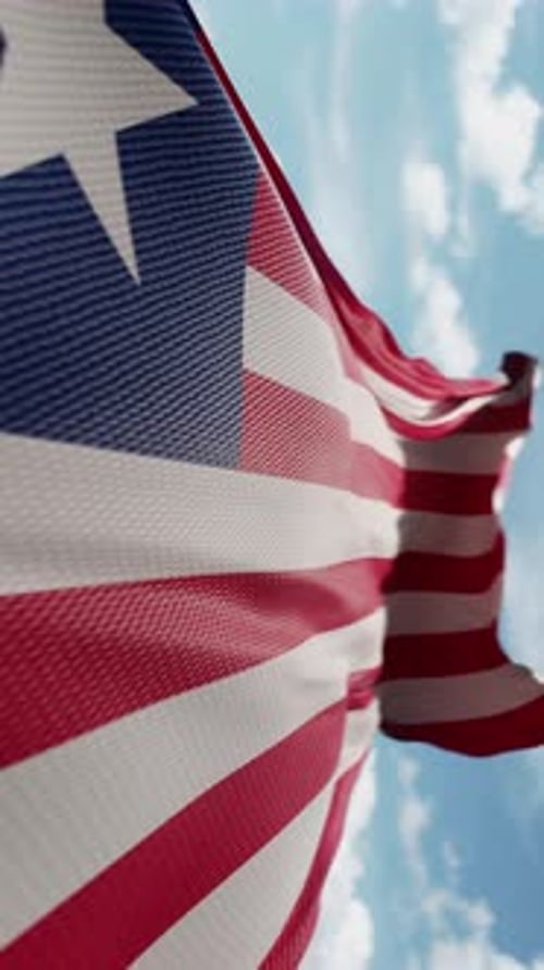 Vertical Waving Patriotic Flag Against Blue Sky