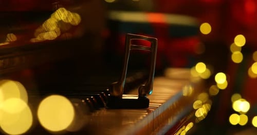 Musical Note Ornament on Piano Keys with Bokeh Lights