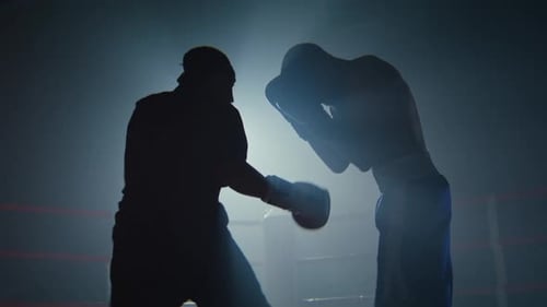 Silhouetten afroamerikanischer Boxer schlagen als Sparrer auf dem Ring