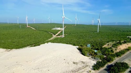 Wind Turbines Turning in Green Field on Sunny Day