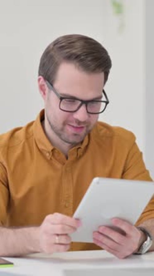 Young Man Using Tablet Receives Good News