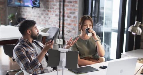 Young Asian man and Asian woman are collaborating in a modern office setting on their business work