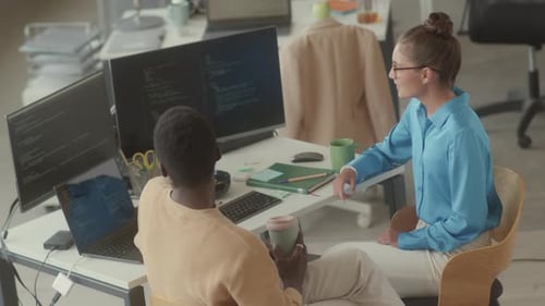 Programmers Having Coffee and Discussing Code in Office