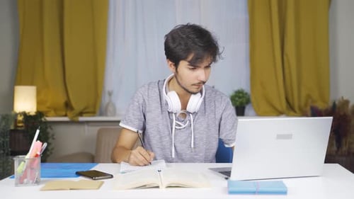 Young Adult Studying at Desk with Laptop