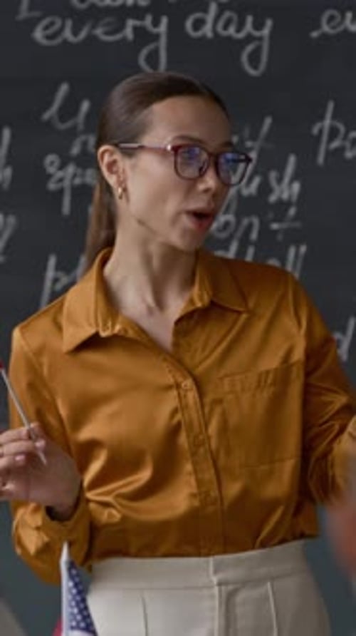 Teacher Explaining English Holding American Flag in Classroom