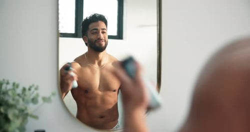 Attractive Man Applying Deodorant in Bright Bathroom
