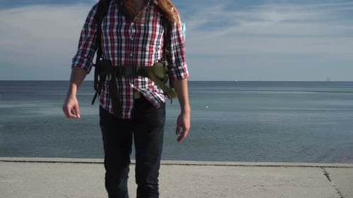 Homme avec sac à dos par Seaside