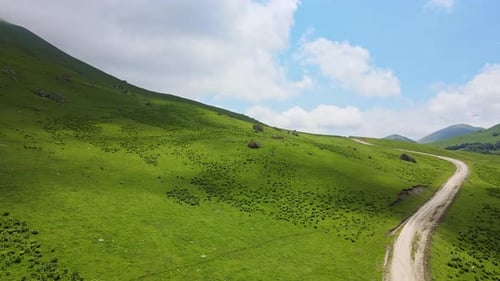 Aerial View of a Beautiful Green Valley and Road in the Mountains